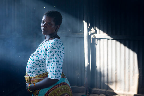 Mirembe Mboje, 32 cooking for her self at the relatives waiting house. Kiomboi District Hospital, in Kiomboi, Tanzania. Photo credit: WaterAid/ Anna Kari.